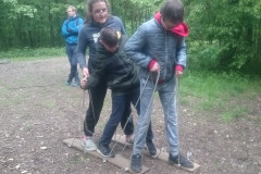Žáci na dřevěných lyžích na laně.