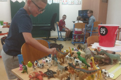 Chlapec si hraje s figurkami zvířátek.