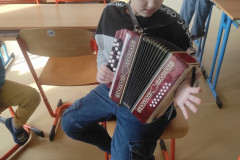 Chlapec zkouší hrát na tahací harmoniku.