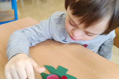 Chlapec zdobí papírový stromeček.