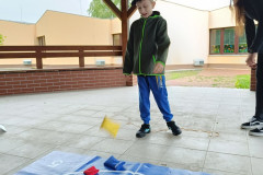 Chlapec hází pytlíky na podložku s terčem.