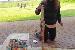 Dívka staví věž z kostek.