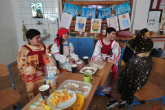 Žáci v kostýmech u stolu s občerstvením.