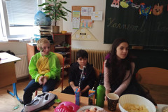Žáci v kostýmech u stolu s občerstvením.