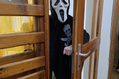 Chlapec v masce ve dveřích.