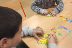Žáci hrají s paní učitelkou deskové hry.
