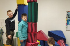 Žáci staví věž z kostek.