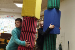 Žáci staví věž z kostek.