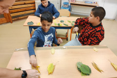 Chlapci vyrábí čelenky lesního skřítka.