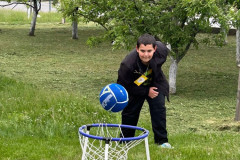 Chlapec hází míč do koše.