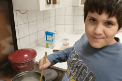 Chlapec míchá pudink na plotně.