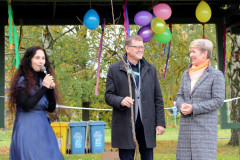 Pozvaní hosté u mikrofonu při přebírání stromku k zasazení.