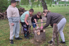 Paní učitelka s žáci řeže kládu.