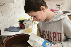 Chlapec dává cukr do hrnce.