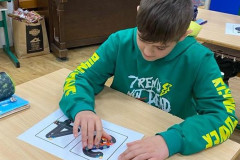 Chlapec ve třídě při nácviku psaní číslic za pomoci autíčka.