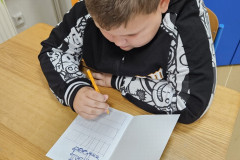 Chlapec píše do sešitu.