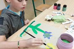 Chlapec maluje kytičku.
