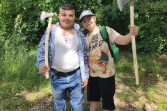 Chlapci ve skanzenu, v rukou mají sekyrky.
