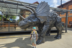 Chlapec v Kovozoo u dinosaura.
