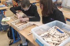 Žáci staví ze stavebnice dům.