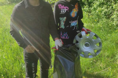 Chlapci sbírají odpadky do pytle.