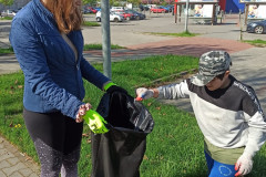 Žáci sbírají odpadky do pytle.