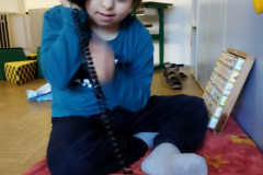 Chlapec si hraje se starým telefonem.