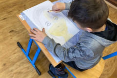 Chlapec kreslí portrét.