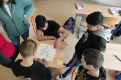 Žáci hrají vyrobené piškvorky s kamínky.
