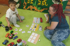 Chlapec s paní asistentkou při hře s autíčky.