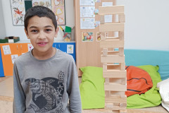 Chlapec a postavěná věž z kostek.