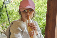 Dívka svačí párek v rohlíku.