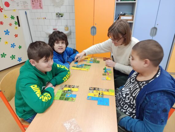 Žáci hrají hru v kroužku deskových her.